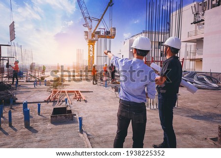 Smart civil architect engineer inspecting and working outdoors structure building site with blueprints. engineering and architecture concept. Royalty-Free Stock Photo #1938225352