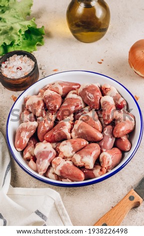 Fresh raw chicken hearts on concrete background. Ready to cook. Selective focus