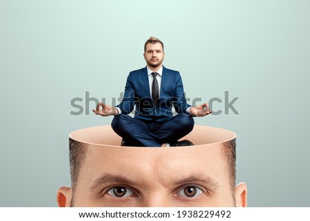 Rest for the brain, close-up of a man's head inside a man in a business suit sitting in the lotus position. Creative background, concept of reload, meditation, calmness, appeasement