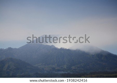 Seen in the distance of Mount Ijen covered with sulfur vapor coming from the crater lake
