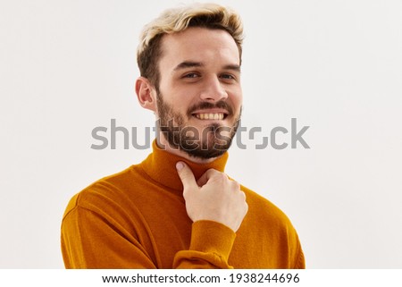 man fashion hairstyle hand near face cropped view light background