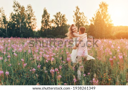 a couple in love walks through a flower meadow. Love and spring blooming. a man embraces a woman