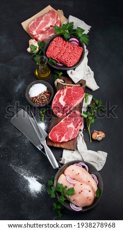 Variety of raw meat  with seasoning  on dark background. Top view  Royalty-Free Stock Photo #1938278968