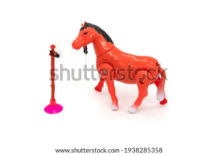 Brown plastic horse toy walking around stick isolated on white.