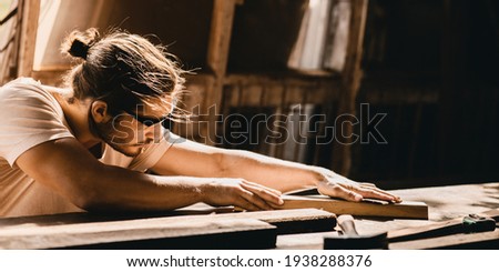 Carpenter man professional skilled in wood work looking detail of masterpiece woodcraft in furniture workshop Royalty-Free Stock Photo #1938288376