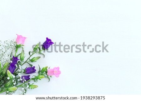 spring bouquet of purple, white and pink bell flowers over white background