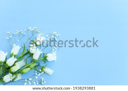 spring bouquet of white bell flowers over blue background