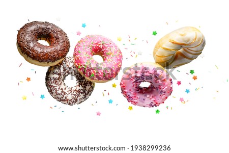 Donuts with sprinkles flying over white background.