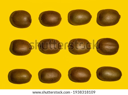 some kiwi fruits arranged on a yellow surface
