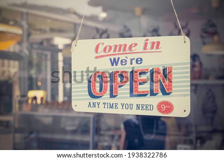 An open sign hanging on the door of a restaurant