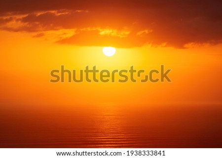 View of bright sunset over misty sea horizon. Auckland, New Zealand.