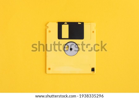 Yellow floppy diskette on yellow background