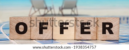 Word OFFER is made of wooden building blocks on swimming pool border. Business Concept.