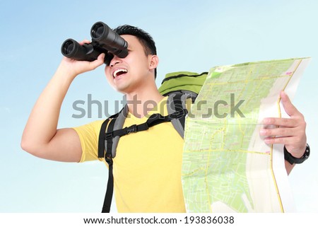 Hiker man tourist looking around with binoculars. Hiking