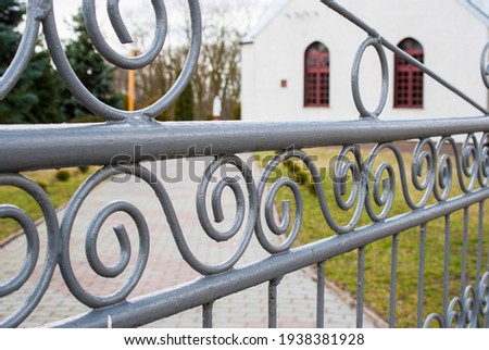 Metal gray gate with curly ornaments. 