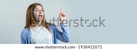 Happy young caucasian female pointing fingers away.