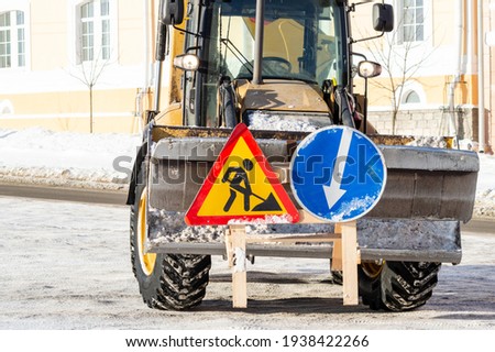 road repair signs on the bucket of the tractor. High quality photo