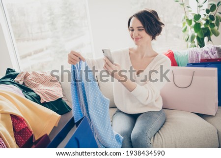 Photo of nice brunette bob haired lady take picture phone dress online shopping sit sofa good mood indoors inside house