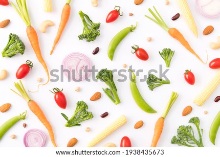 Pattern of vegetables and plant protein. Food background, Top view, Composition of carrot, tomato, shallot, baby corn, broccoli, snow peas with almonds, red bean on a white background. Balanced Vegan 