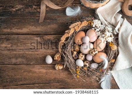 Happy Easter, festive background with eggs in a nest on a wooden background. Top view, horizontal.