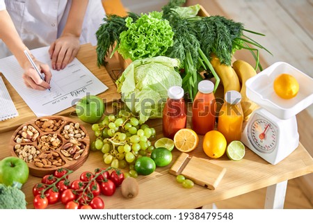 Young Dietitian writing diet plan, view from above on table with different healthy products Royalty-Free Stock Photo #1938479548