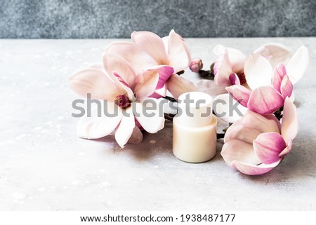 Cosmetics SPA branding mock-up. White cosmetic bottle containers with  pink magnolia flowers on gray background Natural organic beauty product concept