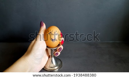 Dekorated Easter egg with a funny emotion on a stand. High quality photo