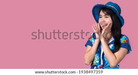 Portrait of a beautiful Asian woman wearing a blue hat and a Hawaiian shirt with a pink background Summer concept