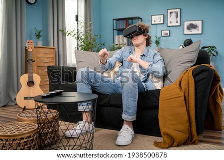 Young man in casual clothes wear the virtual reality glasses is watching and showing imagine via the VR camera and dancing, Technology and innovation concept