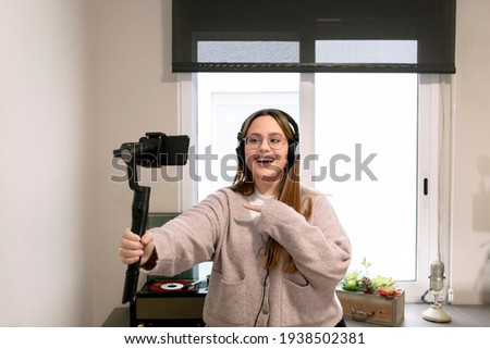 Young vlogger girl talking to her followers using a gimbal while live streaming. Lifestyle concept.