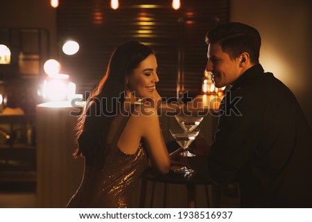 Man and woman flirting with each other in bar Royalty-Free Stock Photo #1938516937