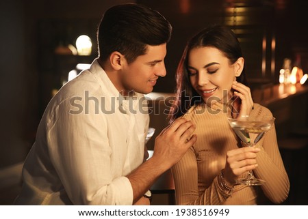 Man and woman flirting with each other in bar Royalty-Free Stock Photo #1938516949