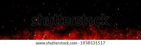 Fire embers particles over black background. Fire sparks background. Abstract dark glitter fire particles lights. bonfire in motion blur. Royalty-Free Stock Photo #1938531517