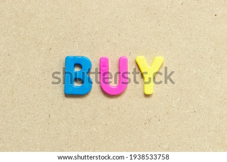 Color alphabet letter with word buy on wood background