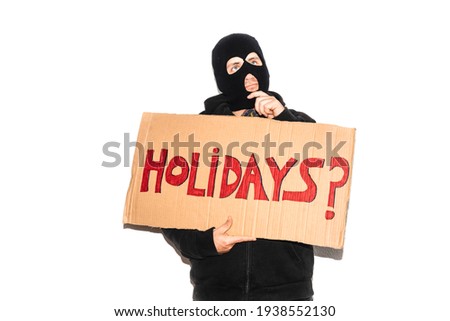 thief, criminal, criminal with balaclava on white background. Head covered person holds a cardboard sign with the text "Holidays?" signed up. home security concept. Robbery and theft at home.