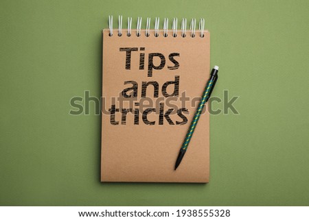 Notebook with text Tips and tricks on green background, top view