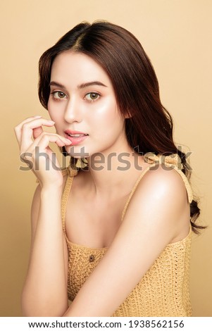 Asian woman are happy with perfect clean healthy skin and beautiful long brown hair. Cute female model clean fresh skin. Expressive facial expressions. Cosmetology concept. Royalty-Free Stock Photo #1938562156