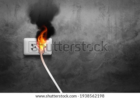 Fire Smoke. Electric wire. Plug socket. Short circuit. Electric plug. Damaged plug. Power socket. Indoor fire. Electrical danger. Electric hazard. Safety hazard. Fire risk. Electric wiring. Emergency  Royalty-Free Stock Photo #1938562198
