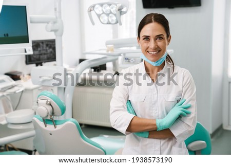 European mid dentist woman smiling while standing in dental clinic Royalty-Free Stock Photo #1938573190