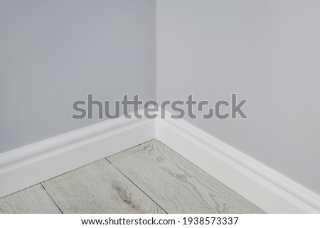 Detail of corner flooring with intricate crown molding and plinth.  Royalty-Free Stock Photo #1938573337