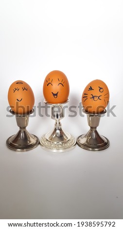 Easter eggs are decorated in the form of cheerful faces on a stand. High quality photo