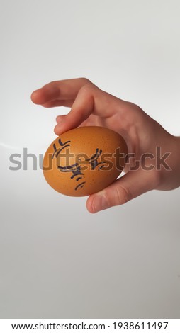 Easter eggs are decorated in the form of cheerful face in his hand. High quality photo