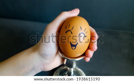 Easter eggs are decorated in the form of cheerful face in his hand. High quality photo