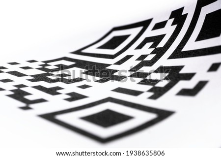 QR code on curled paper. Focus on the center of the code, shallow depth of field