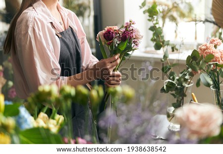 Gardener s in the flower shop make bouquet for a holiday. Lifestyle flower shop. Beautiful flower composition. Detail. Close up
