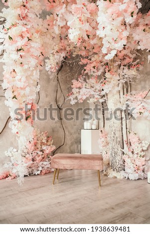 Vertical image pink wedding photo zone in studio made of white flowers. Place for making pictures. Candles and small chair decoration, copy space.

