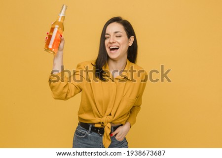 Concept photo of young female drinks beer and has some fun dancing. Wears yellow shirt, isolated yellow color background Royalty-Free Stock Photo #1938673687