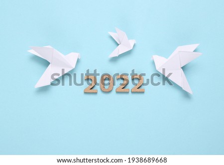Origami doves and 2022 on blue background. Peace symbol