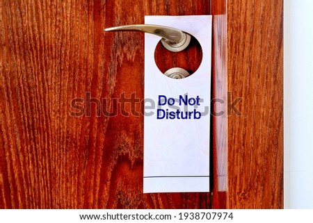 Do Not Disturb sign hang on door knob. Do No Disturb sign at hotel room door. Close-up