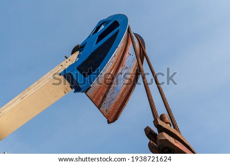 Brightly colored oil pumps produce oil or gas. Detail of the oil pump against the blue sky.